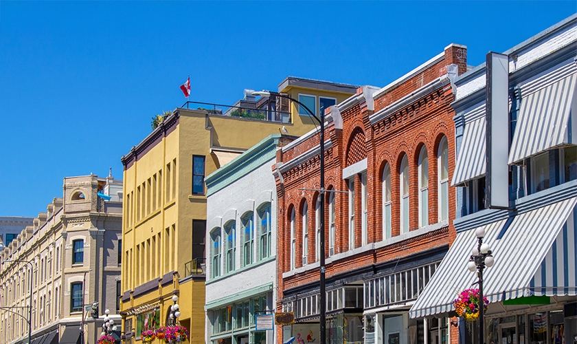 A vibrant downtown street in Canada with historic brick and colourful buildings.