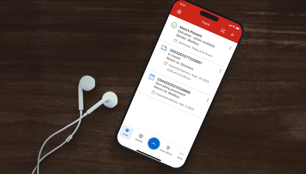 A cellphone is used to track multiple shipments in the Canada Post app. Earbuds rest beside the phone.