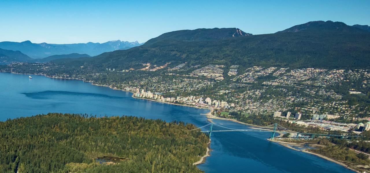 An aerial view of a mountain range and a coastal community.