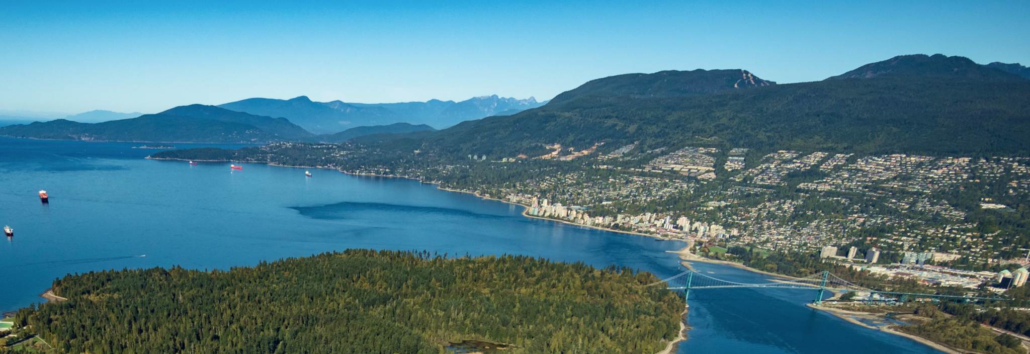 An aerial view of a mountain range and a coastal community.