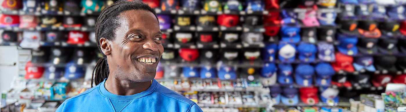 Un propriétaire de petite entreprise est debout dans son magasin de vêtements de sport.