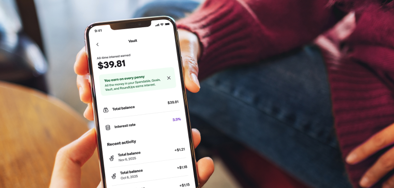A person holds a smartphone open to the “vault” page of the Canada Post MyMoney Account delivered with Koho.
