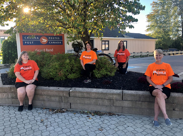 Kathy Hutchinson, Lisa Merner, Andra Brand et Darlene Rumford, des employées de Postes Canada, portent des chandails orange pour souligner leur appui à la Journée du chandail orange