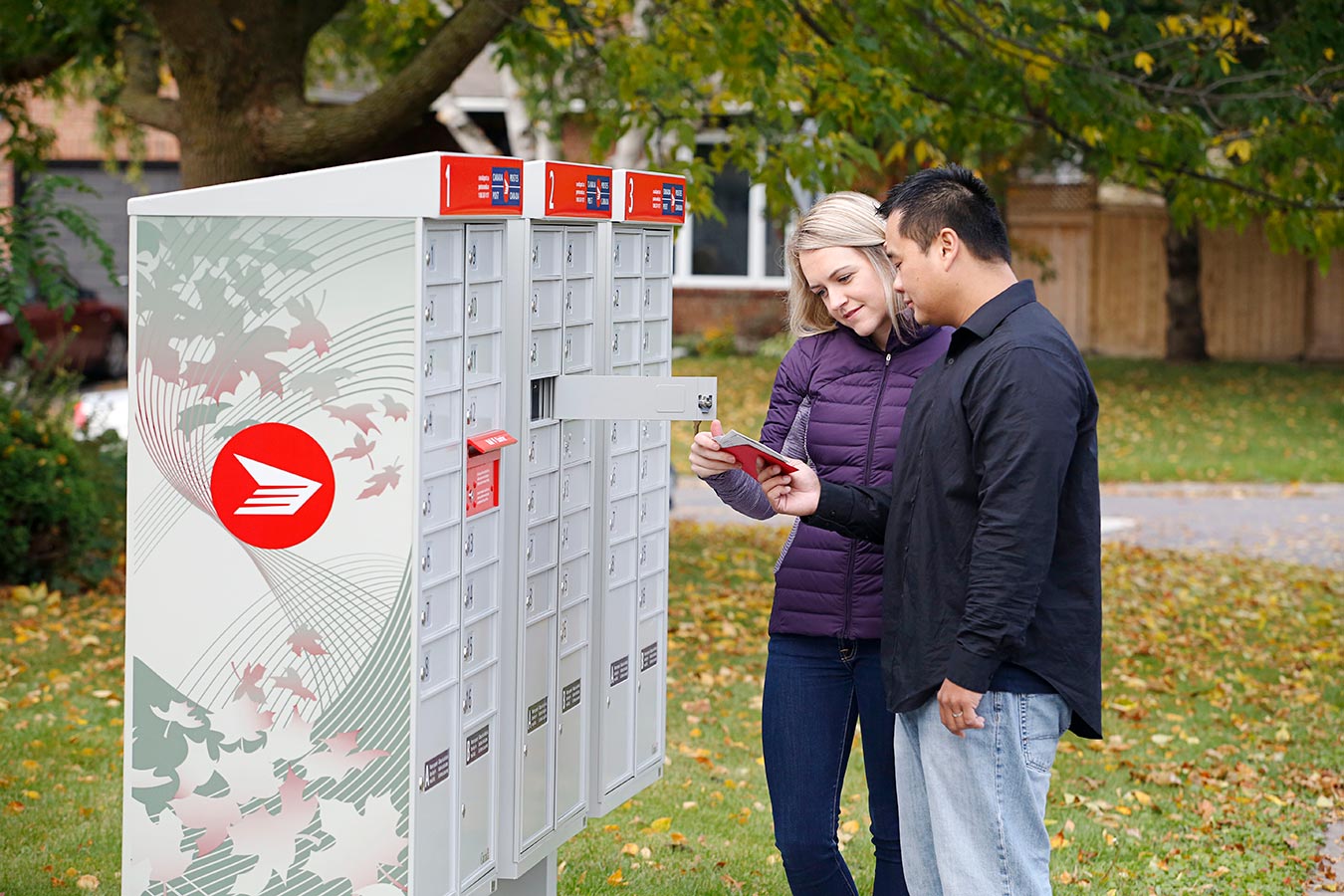 Two people picking up their mail from a community mailbox