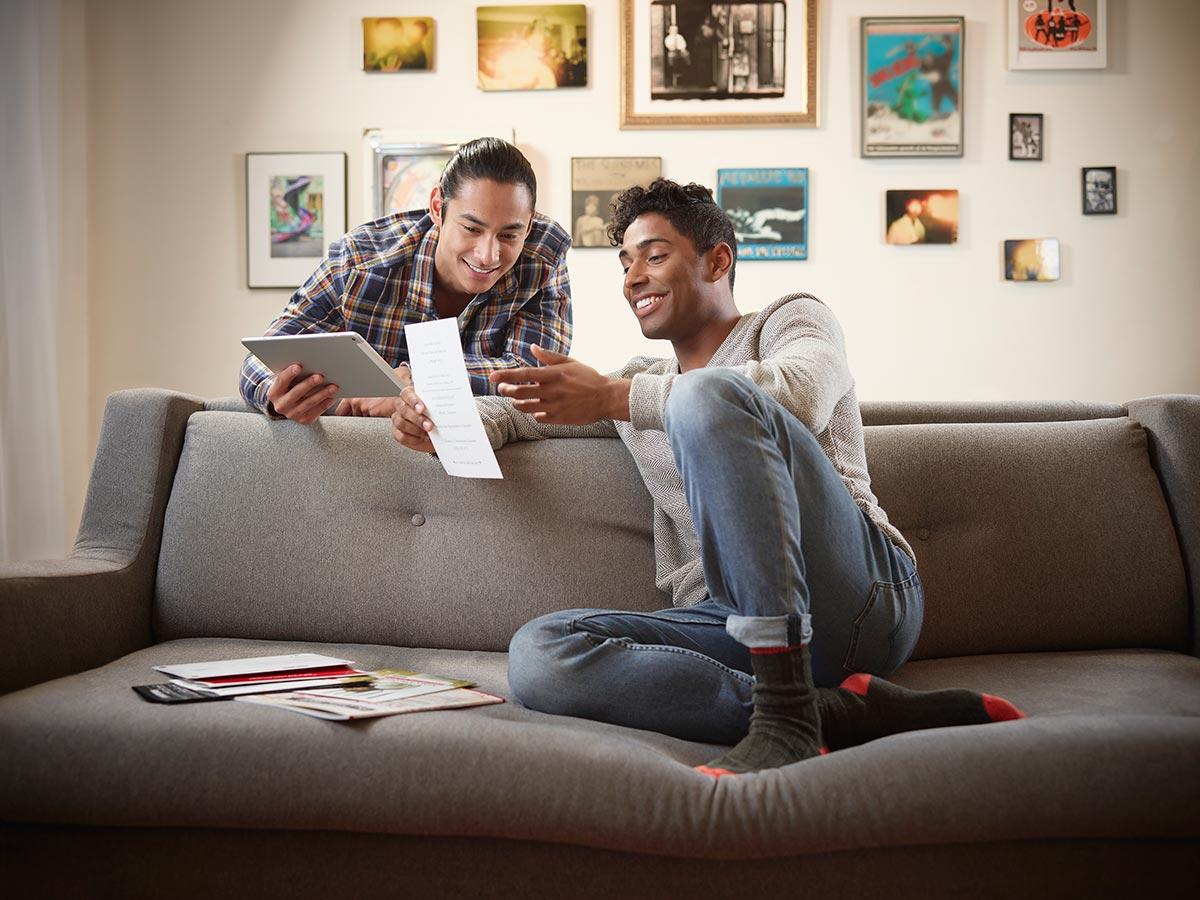 Two men reading a piece of direct mail in a living room