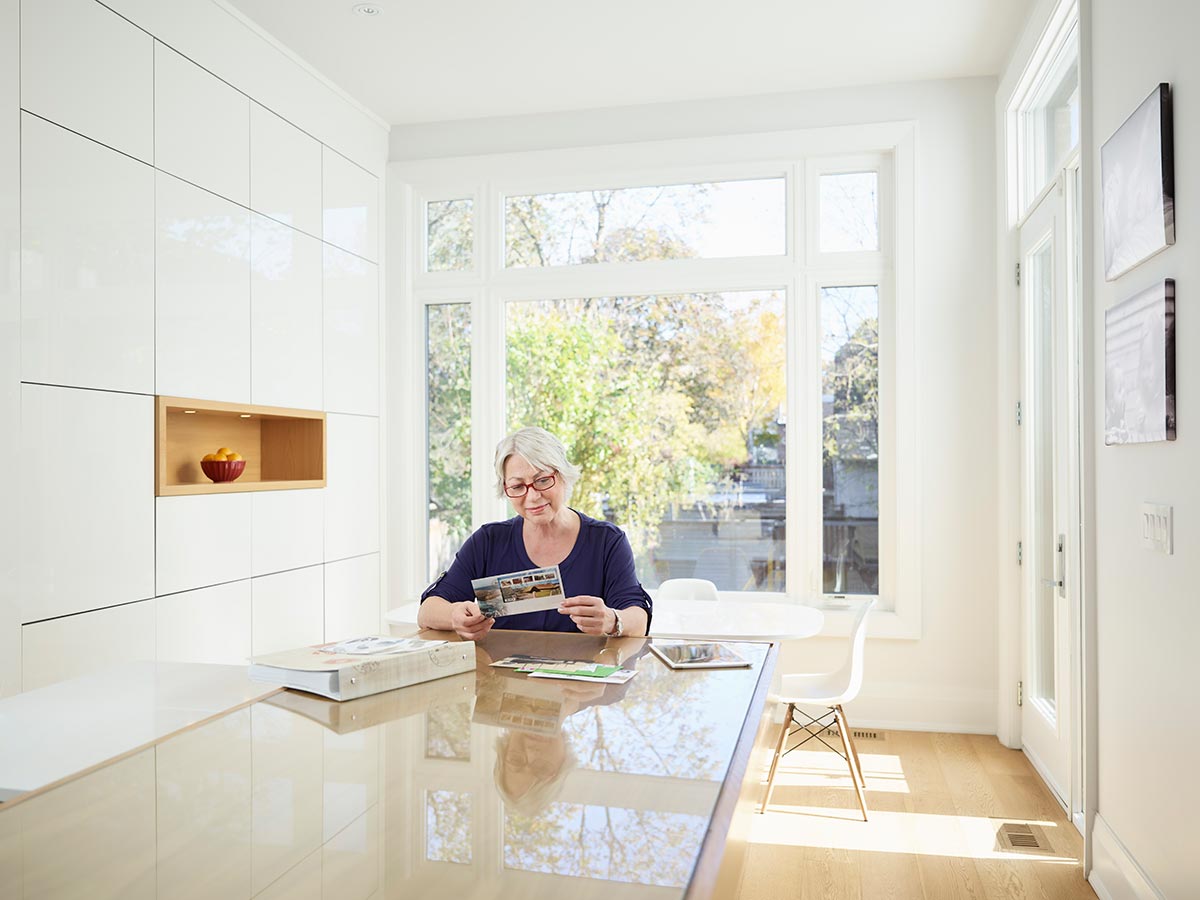 Woman in a kitchen looking through her stamp collection