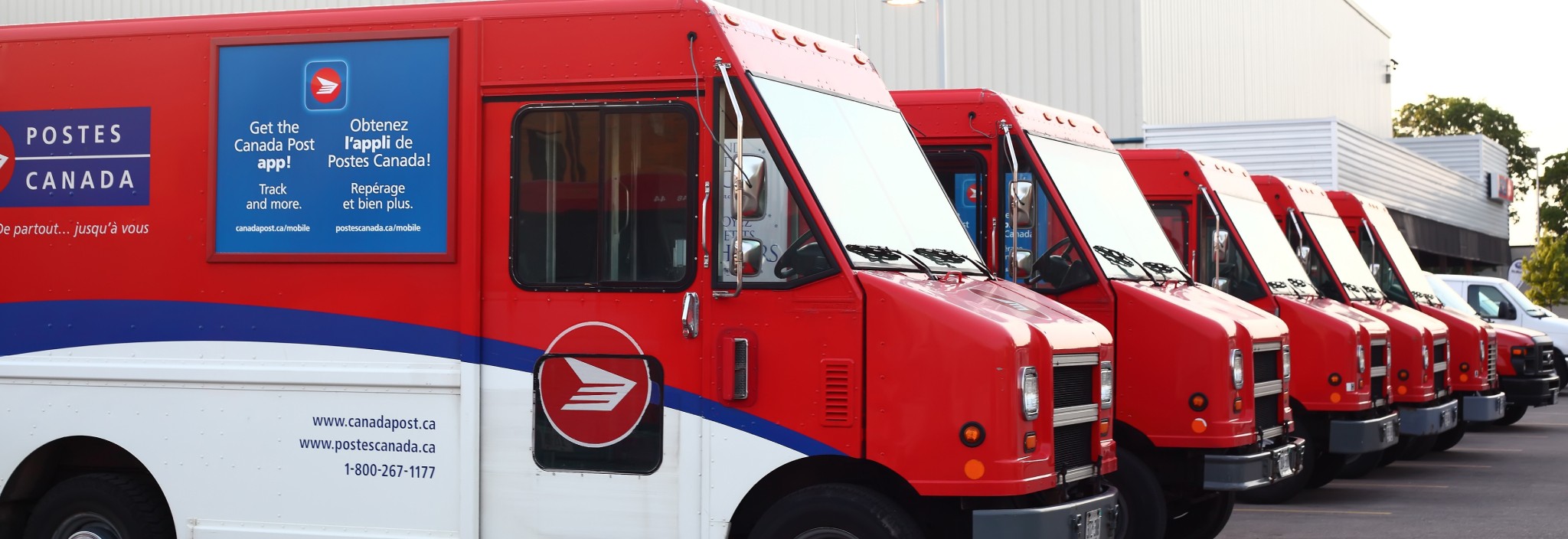 Canada Post delivery trucks parked in a row.