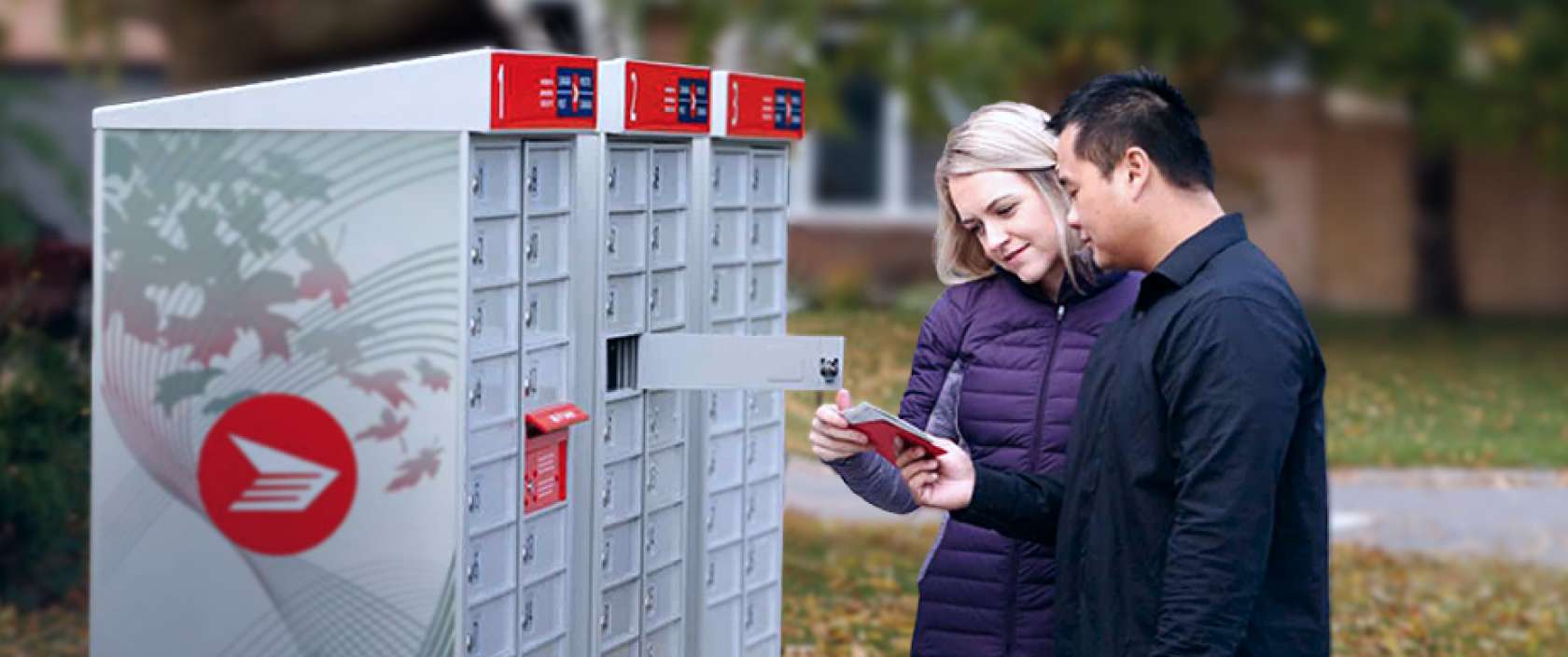 A couple retrieves their mail from a Canada Post community mailbox in a residential area.