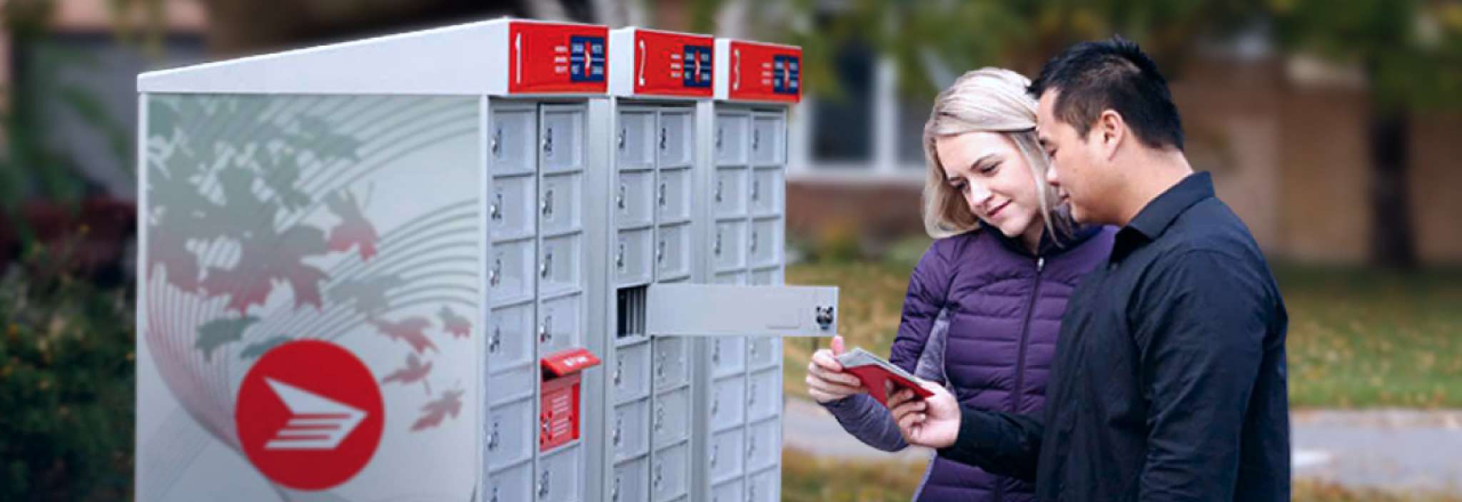 A couple retrieves their mail from a Canada Post community mailbox in a residential area.