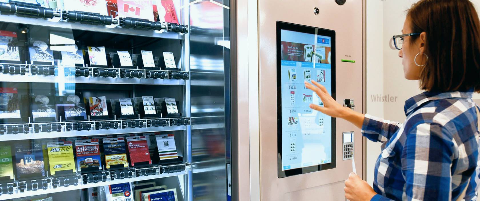 Une femme utilise l’écran tactile d’un distributeur automatique libre-service de Postes Canada pour acheter une carte-cadeau