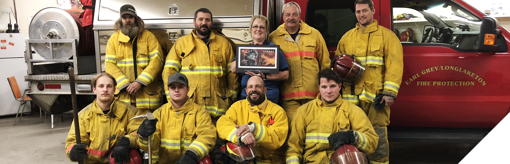 Pompiers d’Earl Grey (Sask.) recevant une plaque spéciale du timbre sur les intervenants d’urgence consacré aux pompiers.