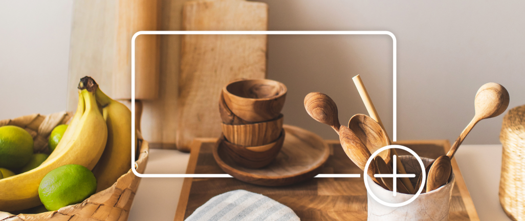 Des ustensiles de cuisine en bois sur un comptoir. Une case blanche avec le signe plus encercle les articles, figurant l’ajout à un panier d’achats en ligne.